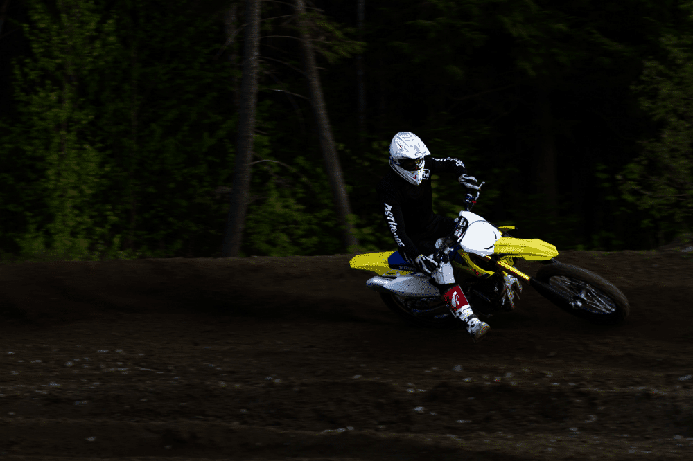 man ridding yellow and white motocross dirt bike