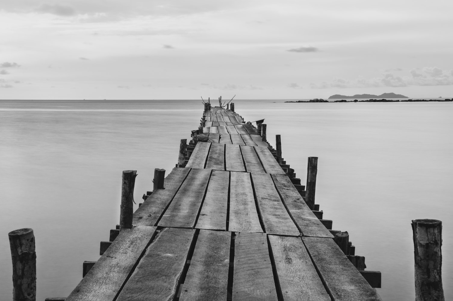 Black and white photography of a beach wooden pier